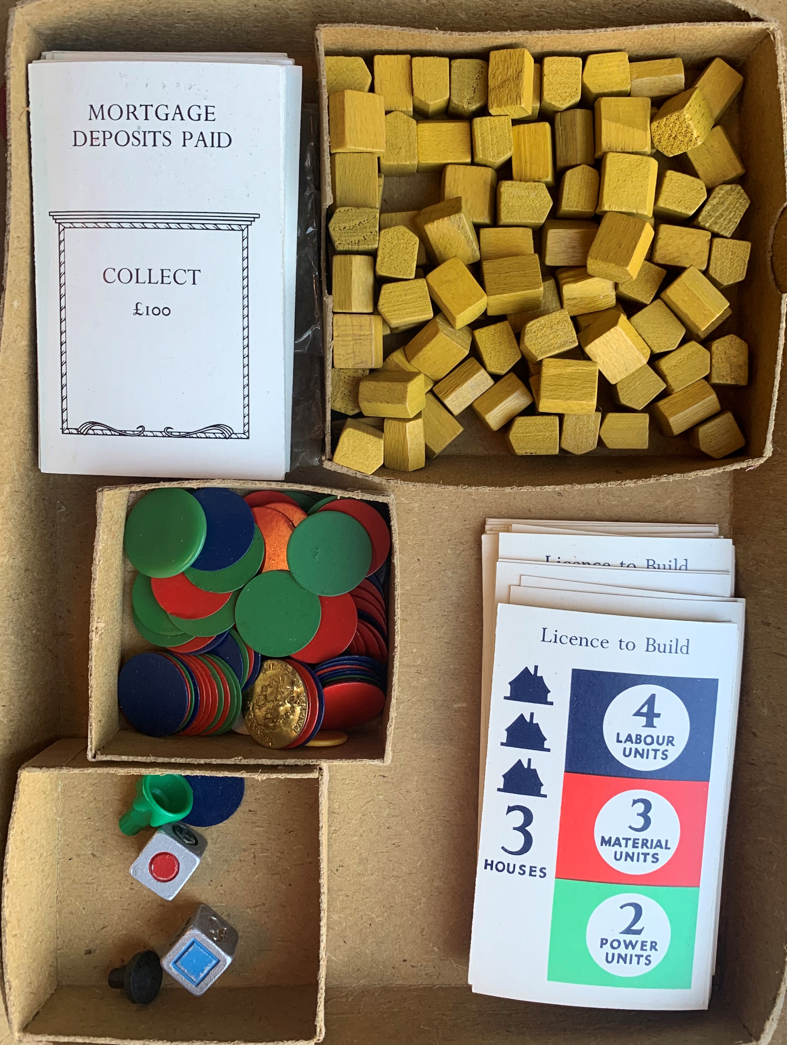 Housing Drive game components including dice, cards and wooden houses